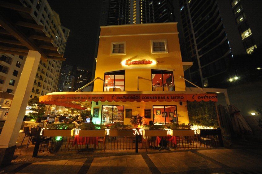 Exterior of L’entrecote BGC corner bar and bistro restaurant at night