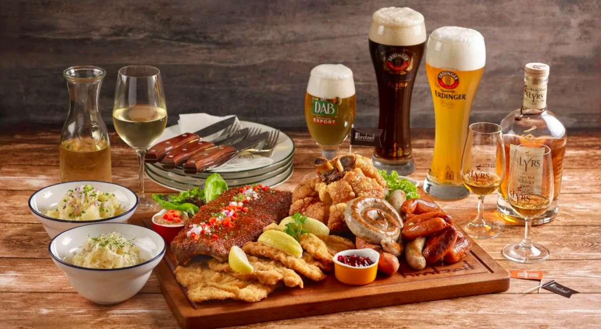  Brotzeit food sampler with mashed potatoes, beer, whiskey, sausages, and schnitzel